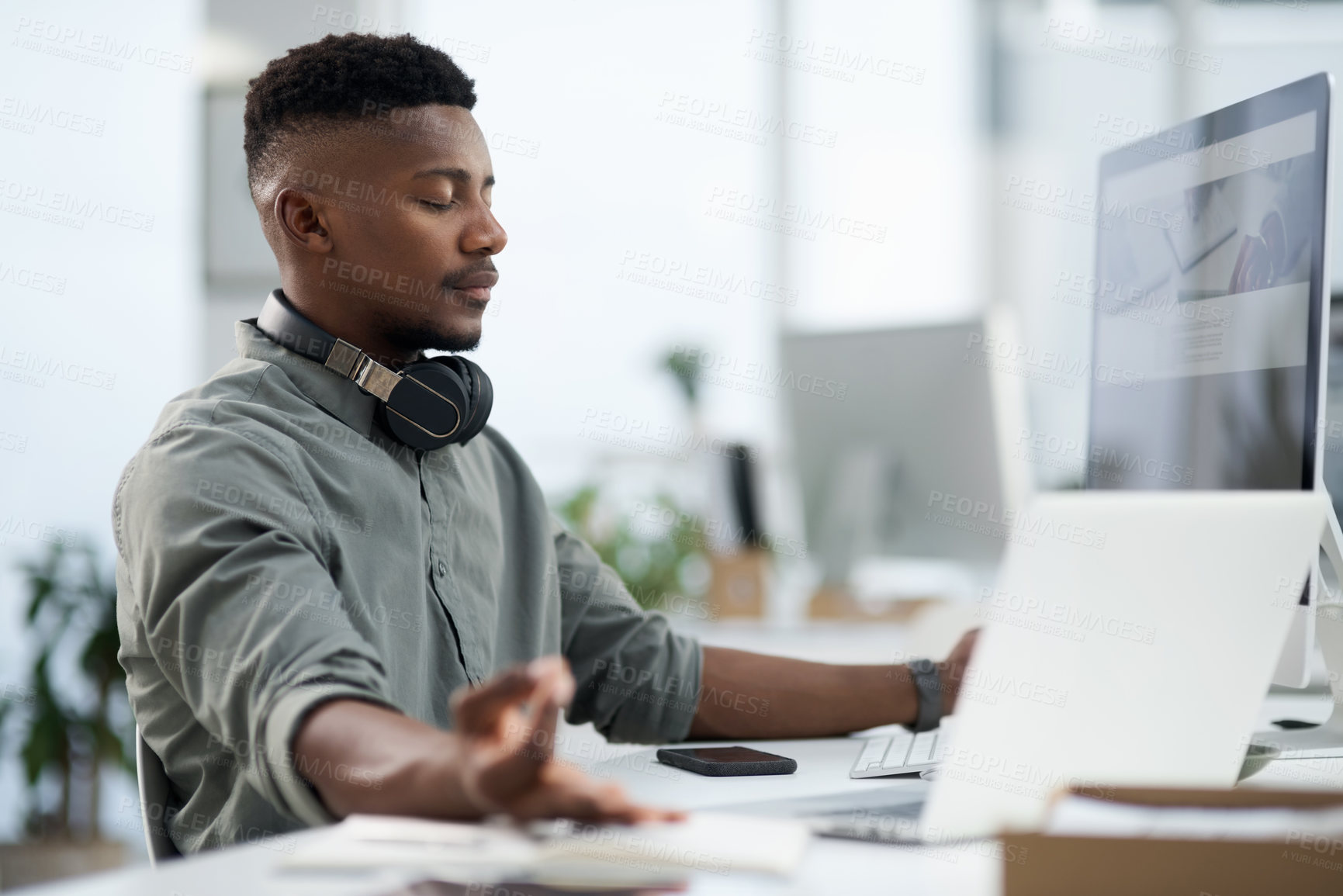 Buy stock photo Shot of a young man meditating in at work