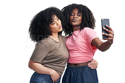 Buy stock photo Studio shot of two young women using a smartphone to take selfies against a white background