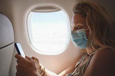Buy stock photo Shot of a woman using her phone in the aeroplane