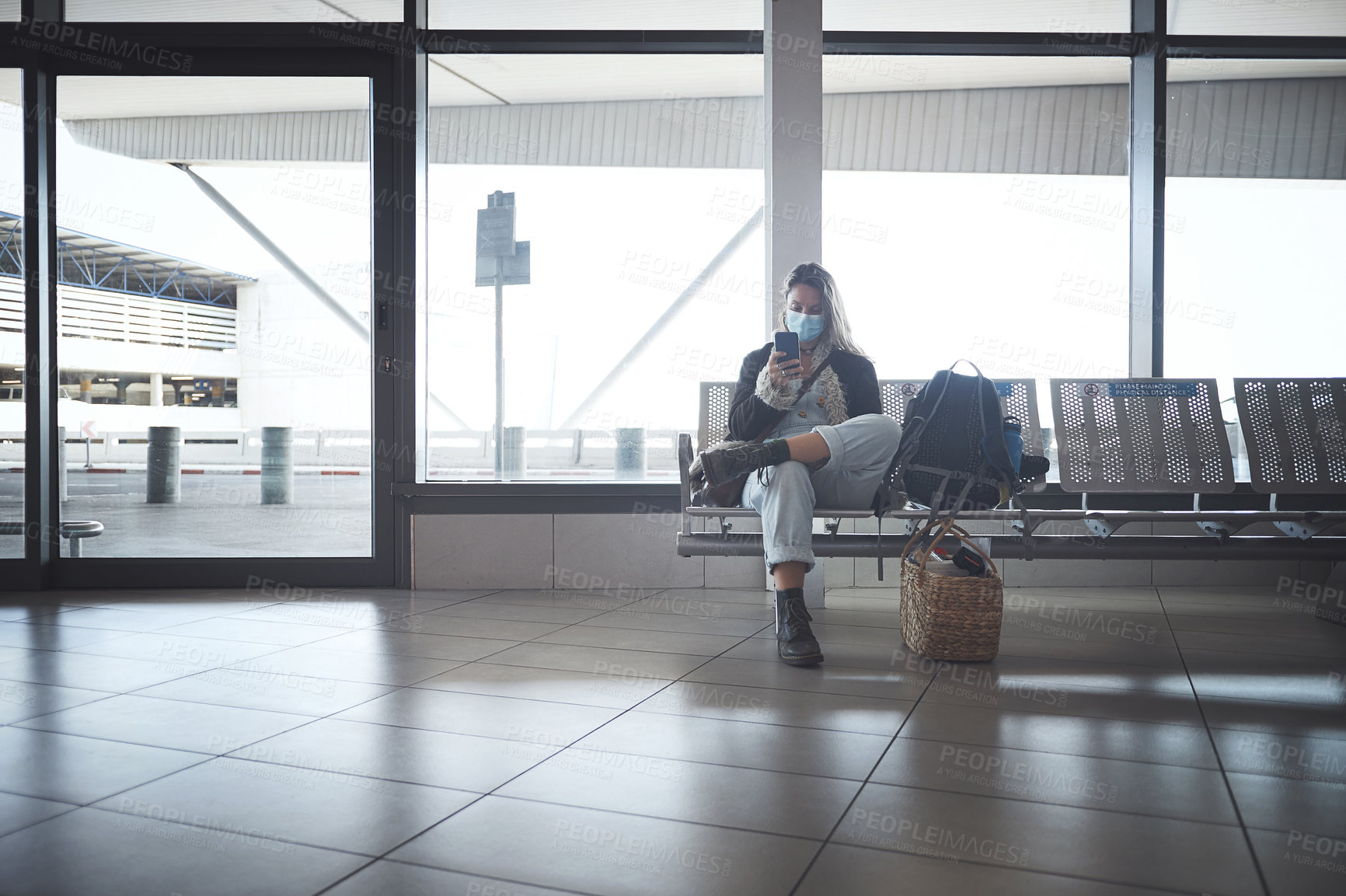 Buy stock photo Shot a young woman sitting with a bags in the airport