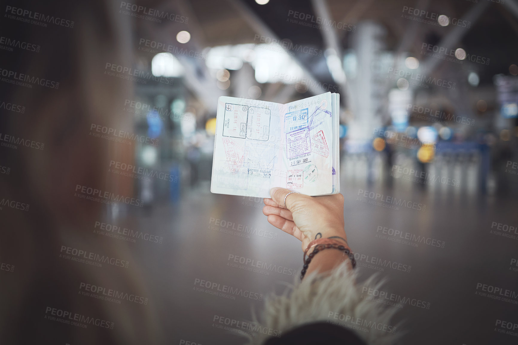 Buy stock photo Cropped shot of a woman showing her passport stamps at the airport