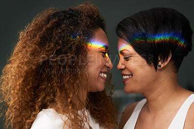 Buy stock photo Shot of an affectionate couple standing together at home with a rainbow lens flare over their faces