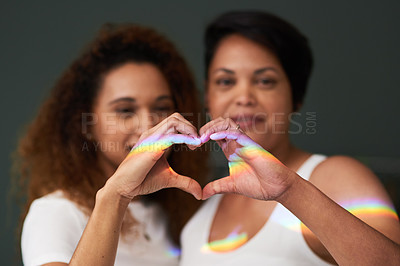 Buy stock photo Shot of an affectionate couple standing together and forming a heart shape with their hands