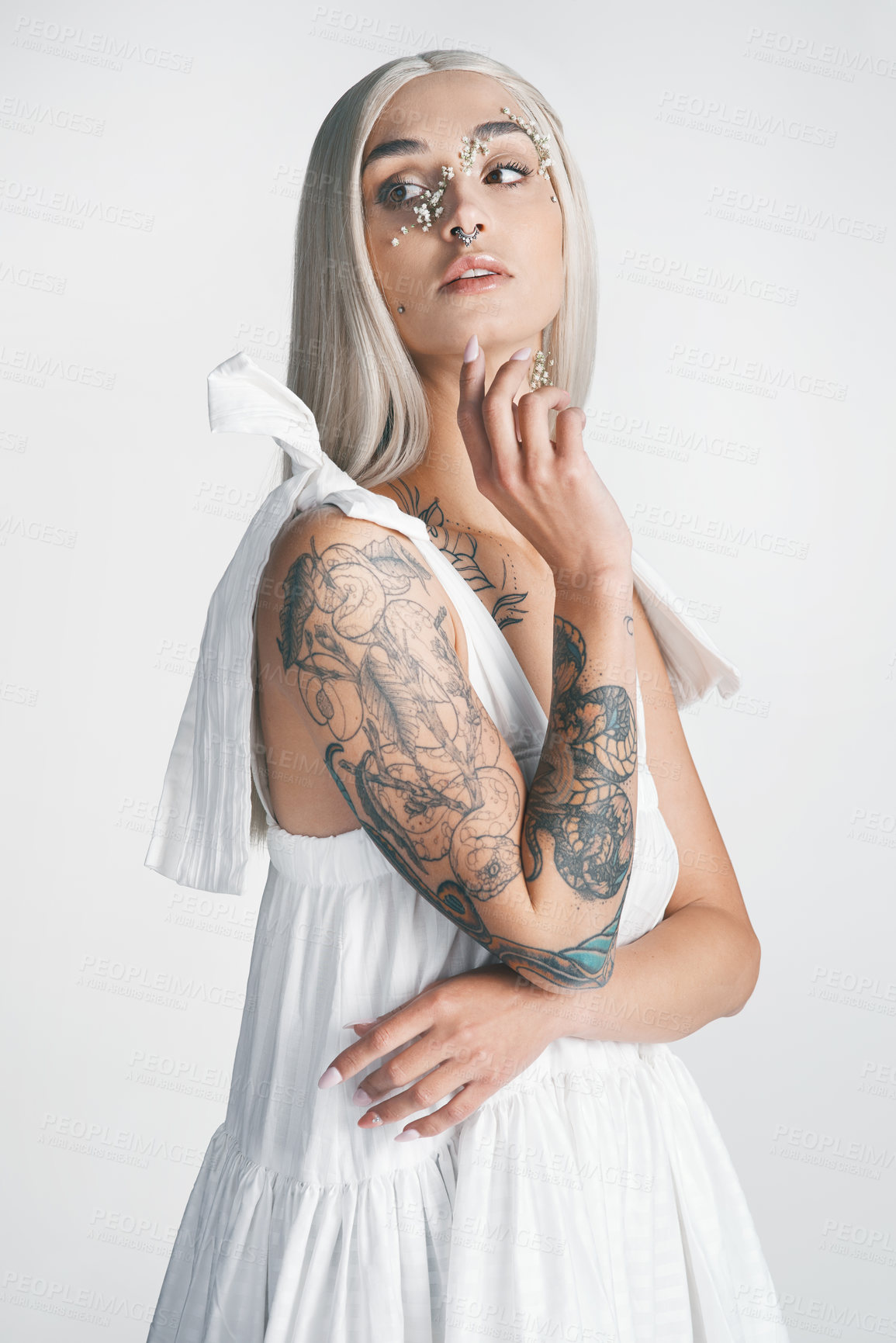 Buy stock photo Cropped shot of an attractive young woman looking thoughtful while posing against a grey background in studio