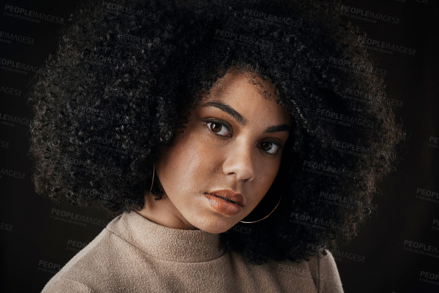 Buy stock photo Cropped portrait of an attractive young woman posing in studio against a dark background