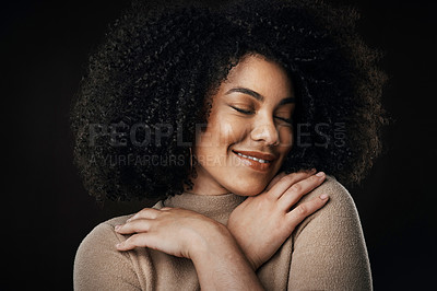 Buy stock photo Cropped shot of an attractive young woman posing in studio against a dark background