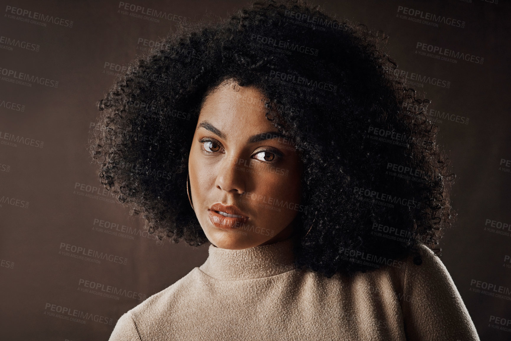 Buy stock photo Cropped portrait of an attractive young woman posing in studio against a dark background