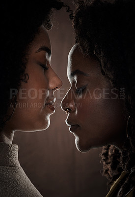Buy stock photo Cropped shot of a beautiful young female couple posing in studio against a dark background