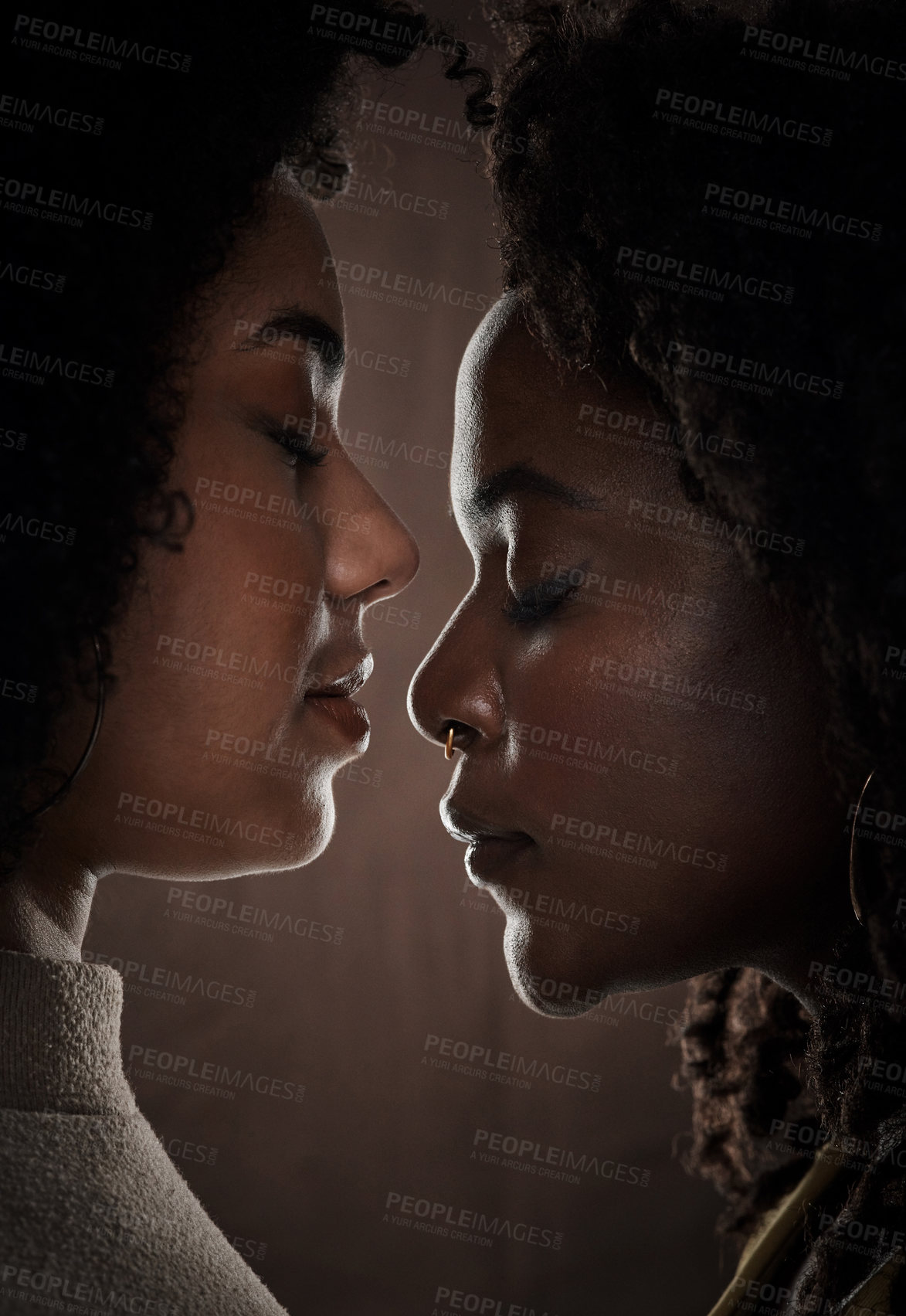 Buy stock photo Cropped shot of a beautiful young female couple posing in studio against a dark background