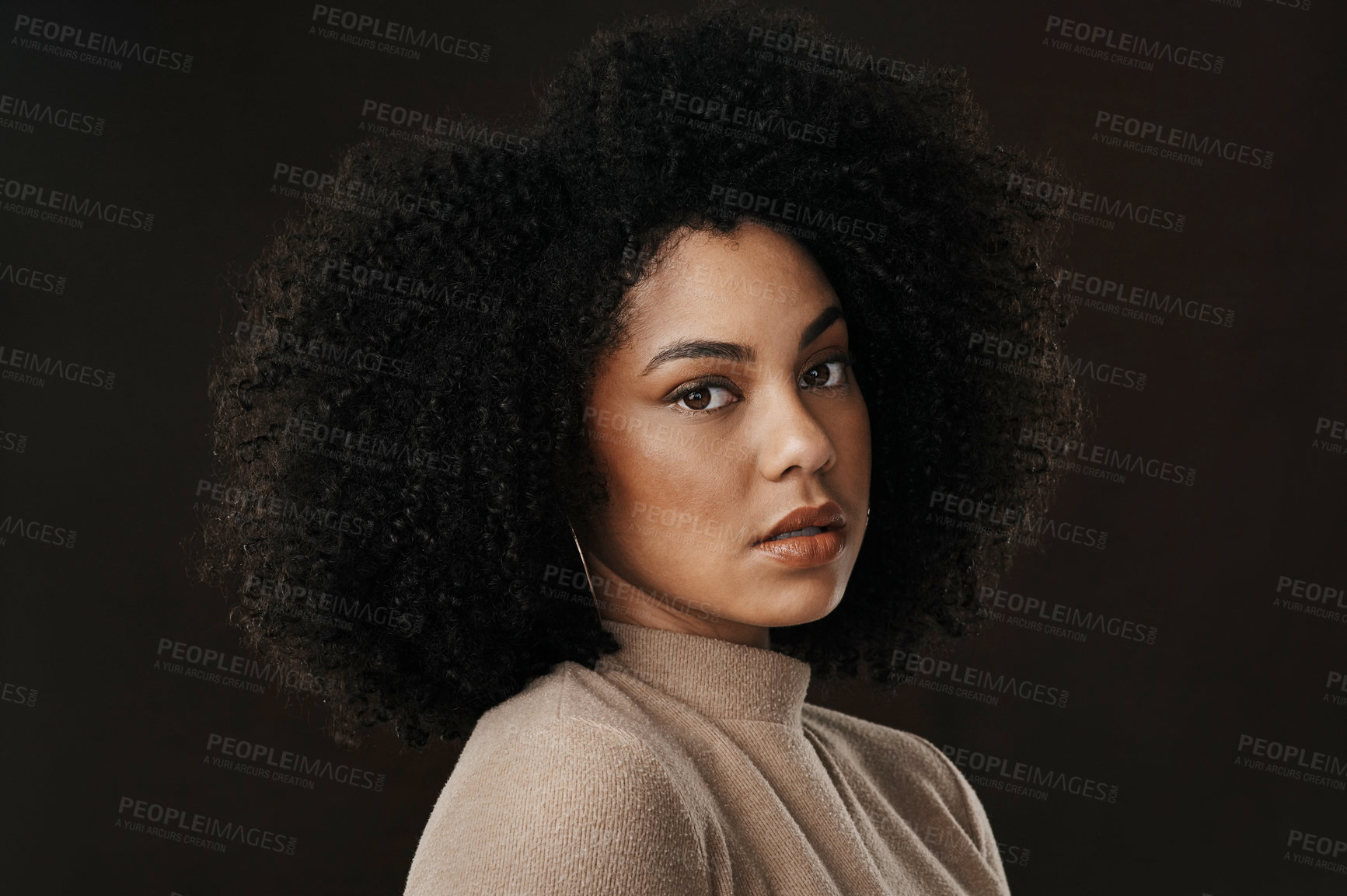 Buy stock photo Cropped portrait of an attractive young woman posing in studio against a dark background