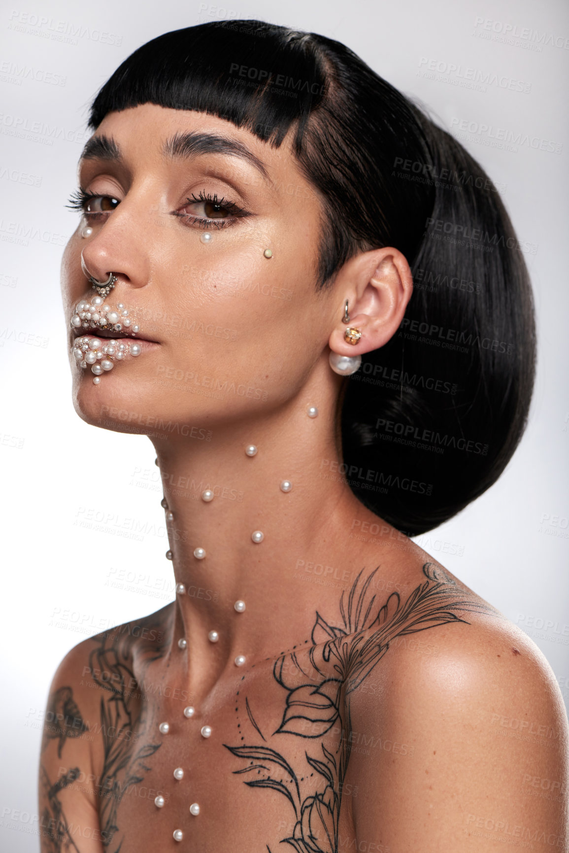 Buy stock photo Studio portrait of a beautiful young woman with pearls on her face posing against a grey background