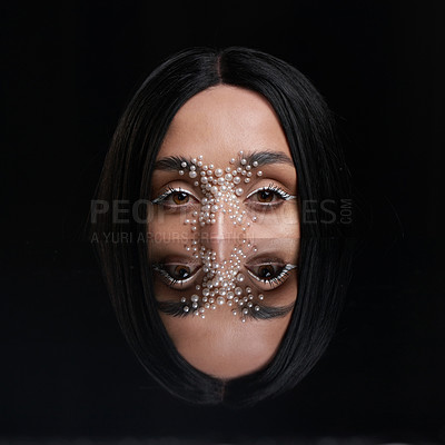 Buy stock photo Studio portrait of a beautiful young woman with pearls on her face posing against a black background