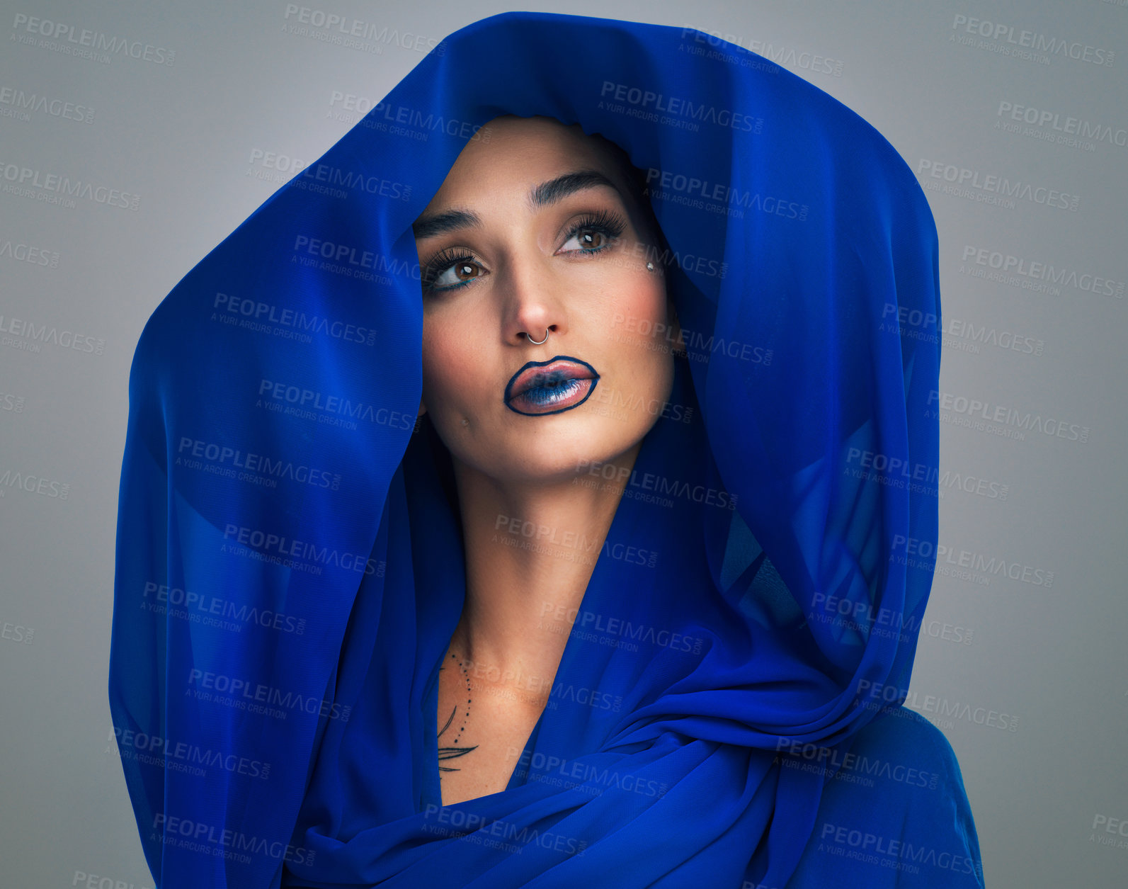 Buy stock photo Studio shot of a beautiful young woman looking thoughtful while posing against a grey background