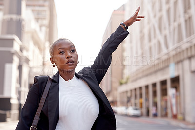 Buy stock photo Shot of a young businesswoman gesturing for a taxi in the city