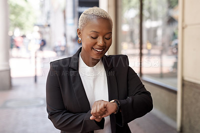 Buy stock photo Shot of a young businesswoman checking the time on her wristwatch while out in the city