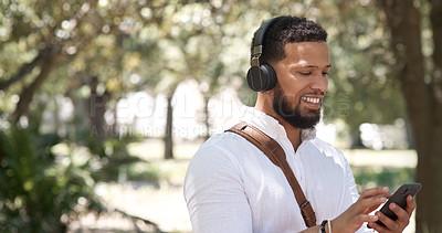 Buy stock photo Businessman, typing and phone music in nature, communication and chat in the morning. Smile, young and employee listening to a podcast, radio or streaming audio on a mobile in a park for a commute