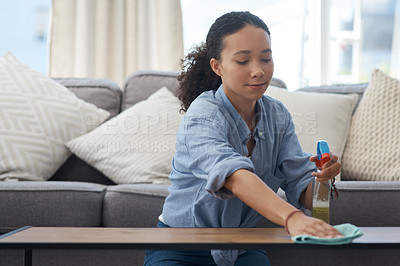 Buy stock photo Shot of a young woman cleaning down her wood coffee table at home