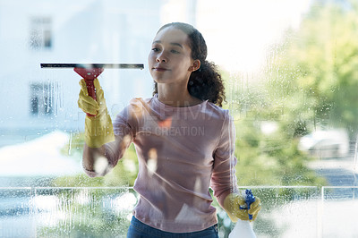 Buy stock photo Shot of a young woman cleaning her window at home