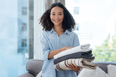 Buy stock photo Portrait, laundry and cleaning with a black woman in her home, holding fresh towels during housework. Smile, fabric and washing with a happy young female cleaner in the living room of her apartment