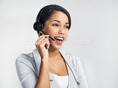 Buy stock photo Studio shot of a confident young businesswoman using a headset against a grey background
