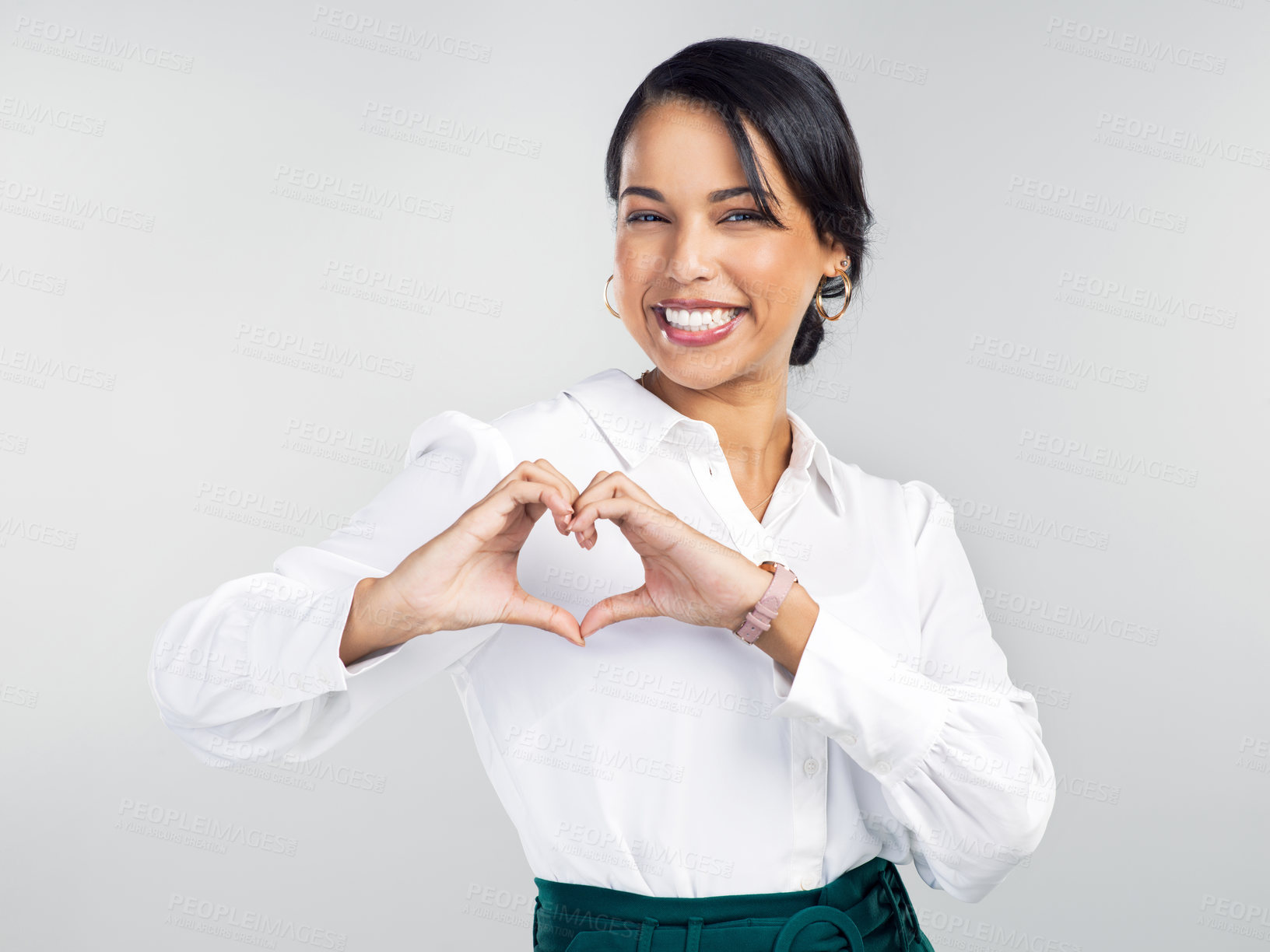 Buy stock photo Studio shot of a young businesswoman making a heart shaped gesture with her hands against a grey background