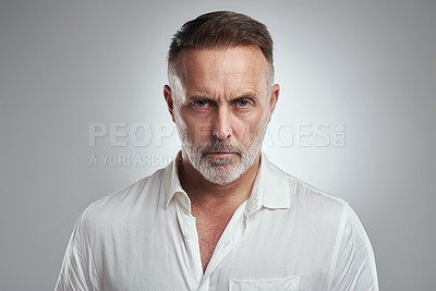 Buy stock photo Studio portrait of a mature man looking angry against a grey background