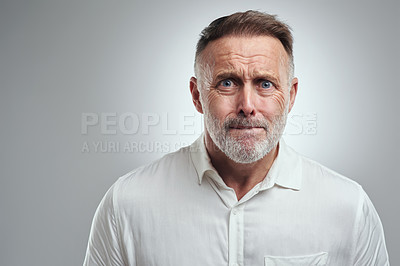 Buy stock photo Studio portrait of a mature man looking scared against a grey background