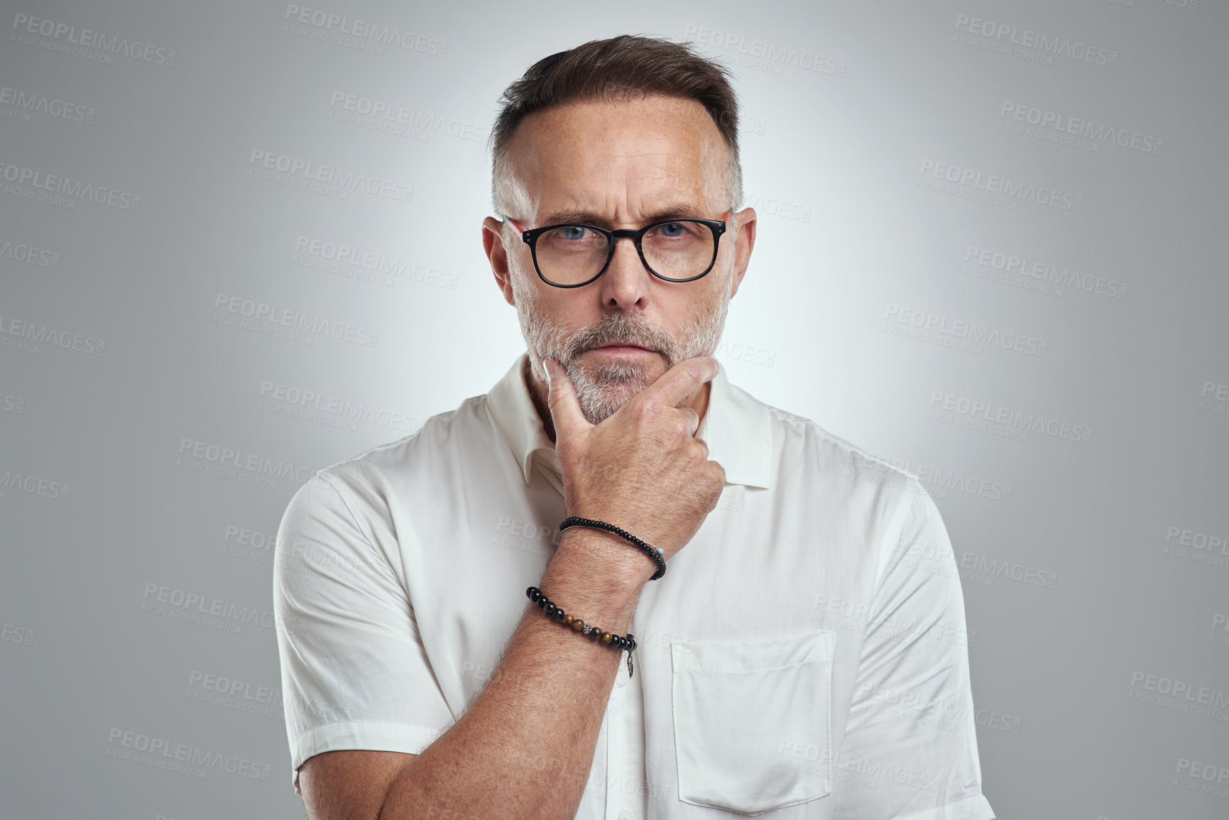 Buy stock photo Studio portrait of a mature man looking thoughtful against a grey background