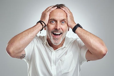 Buy stock photo Studio portrait of a mature man looking surprised against a grey background