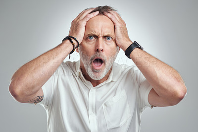 Buy stock photo Studio portrait of a mature man looking surprised against a grey background