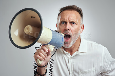 Buy stock photo Studio portrait of a mature man using a megaphone against a grey background