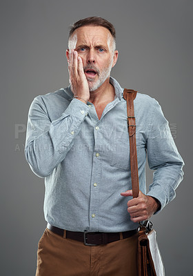Buy stock photo Studio portrait of a mature man looking stressed out against a grey background