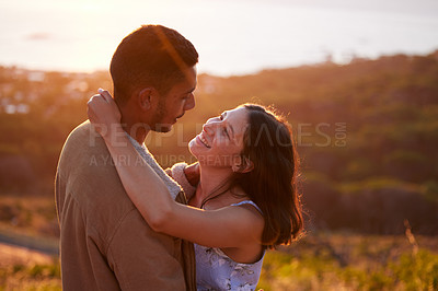 Buy stock photo Smile, nature and couple hug at sunset for romance, love and care together outdoor at garden. Interracial, man and woman in the countryside to embrace for connection, commitment and support on date