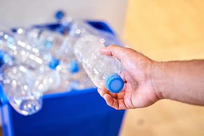 Buy stock photo Cropped shot of a man putting a bottle in the recycling bin at home