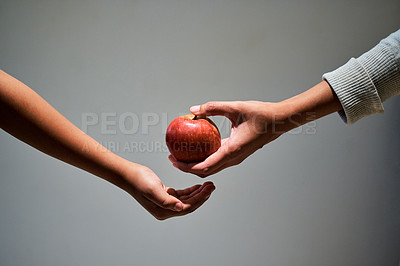 Buy stock photo Studio shot of a unrecognizable woman offering a child an apple