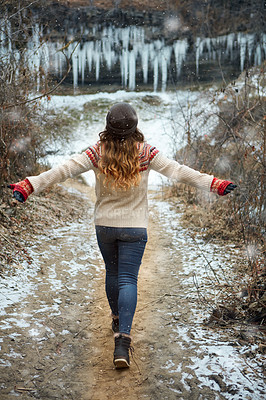 Buy stock photo Rearview shot of an unrecognizable young woman spending the day outside during winter
