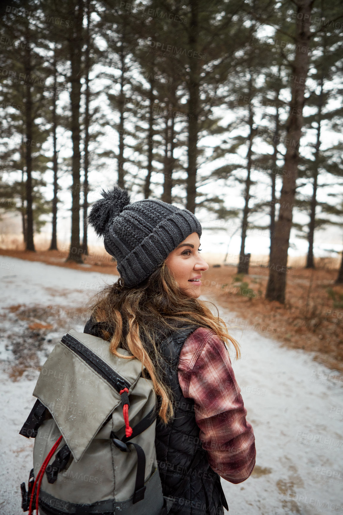 Buy stock photo Rearview shot of a young woman hiking in the wilderness during winter