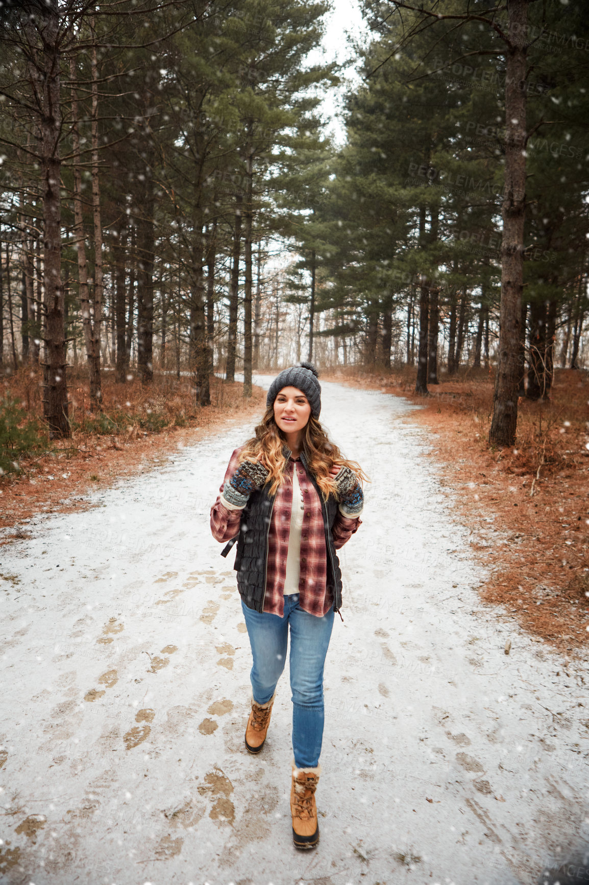 Buy stock photo Shot of a young woman hiking in the wilderness during winter