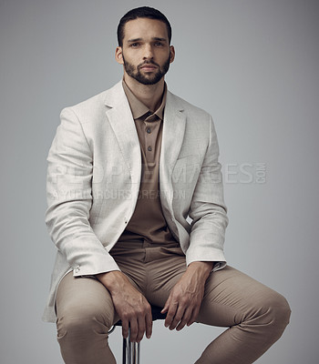 Buy stock photo Shot of a handsome young man sitting alone in the studio during the day