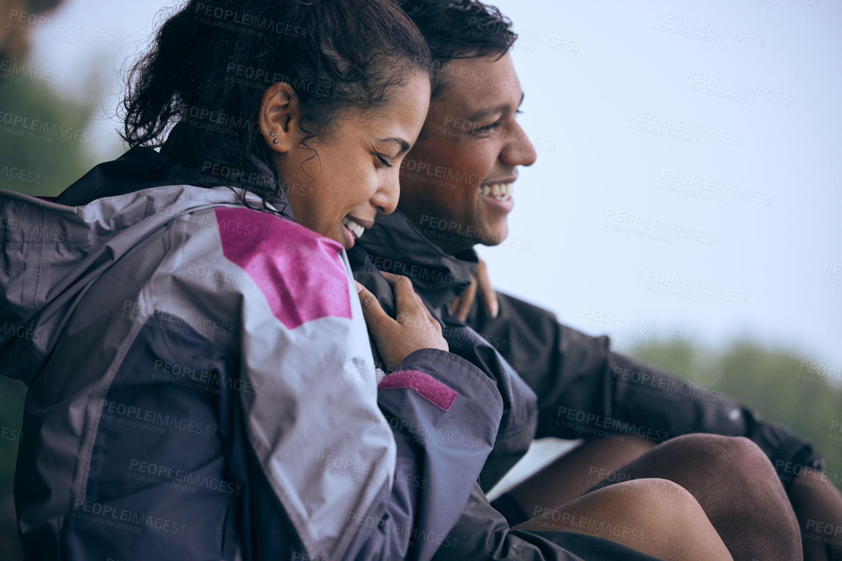 Buy stock photo Cropped shot of an affectionate young couple laughing while taking a break during their early morning hike
