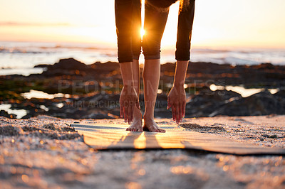 Buy stock photo Cropped shot of an unrecognizable woman doing yoga alone on the beach at sunset