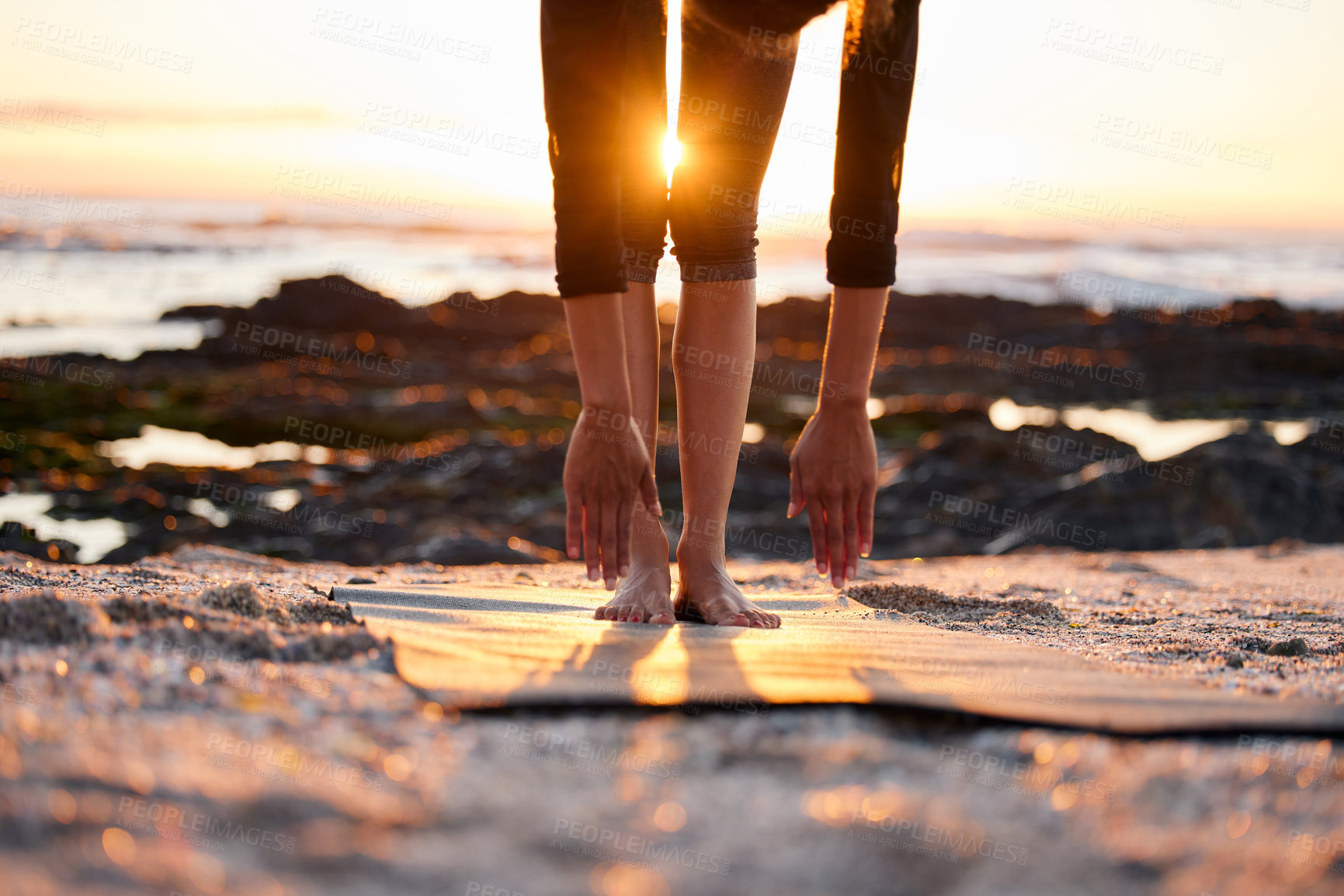 Buy stock photo Hands, legs and sunshine with beach yoga, fitness and outdoor with lens flare and ocean for calm and zen. Yogi person, exercise or workout on shore, pilates and energy with stretching for self care