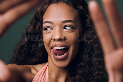 Buy stock photo Selfie, tongue out and happy gen z girl with natural beauty, hair or smile on green background. Face, emoji and female influencer with fun, quirky or silly in studio for profile picture or blog