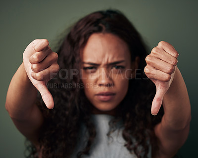 Buy stock photo Studio, portrait and hands of woman with thumbs down for bad review, vote and decision on green background. Female person, frown and finger with gesture for fake news, rejection and negative rating
