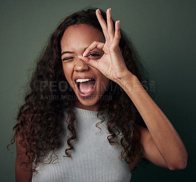 Buy stock photo Circle, hand and portrait of black woman in studio for peek a boo or i see you, perfect sign and wow. Girl, isolated and green background with ok gesture for feedback and expression with approval.