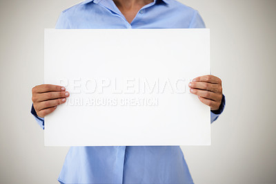 Buy stock photo Studio shot of an unrecognisable businesswoman holding up a blank sign against a grey background