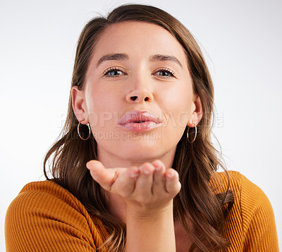 Buy stock photo Studio shot of a young woman blowing a kiss against a white background