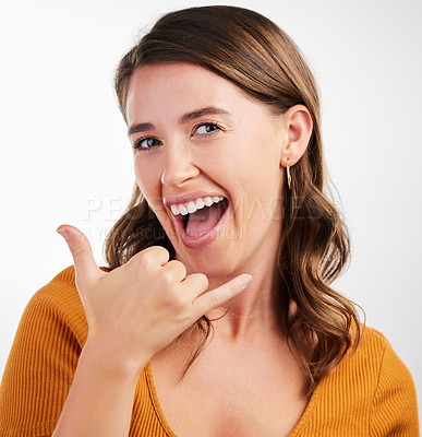 Buy stock photo Studio shot of a young woman making a phone sign with her hand against a background