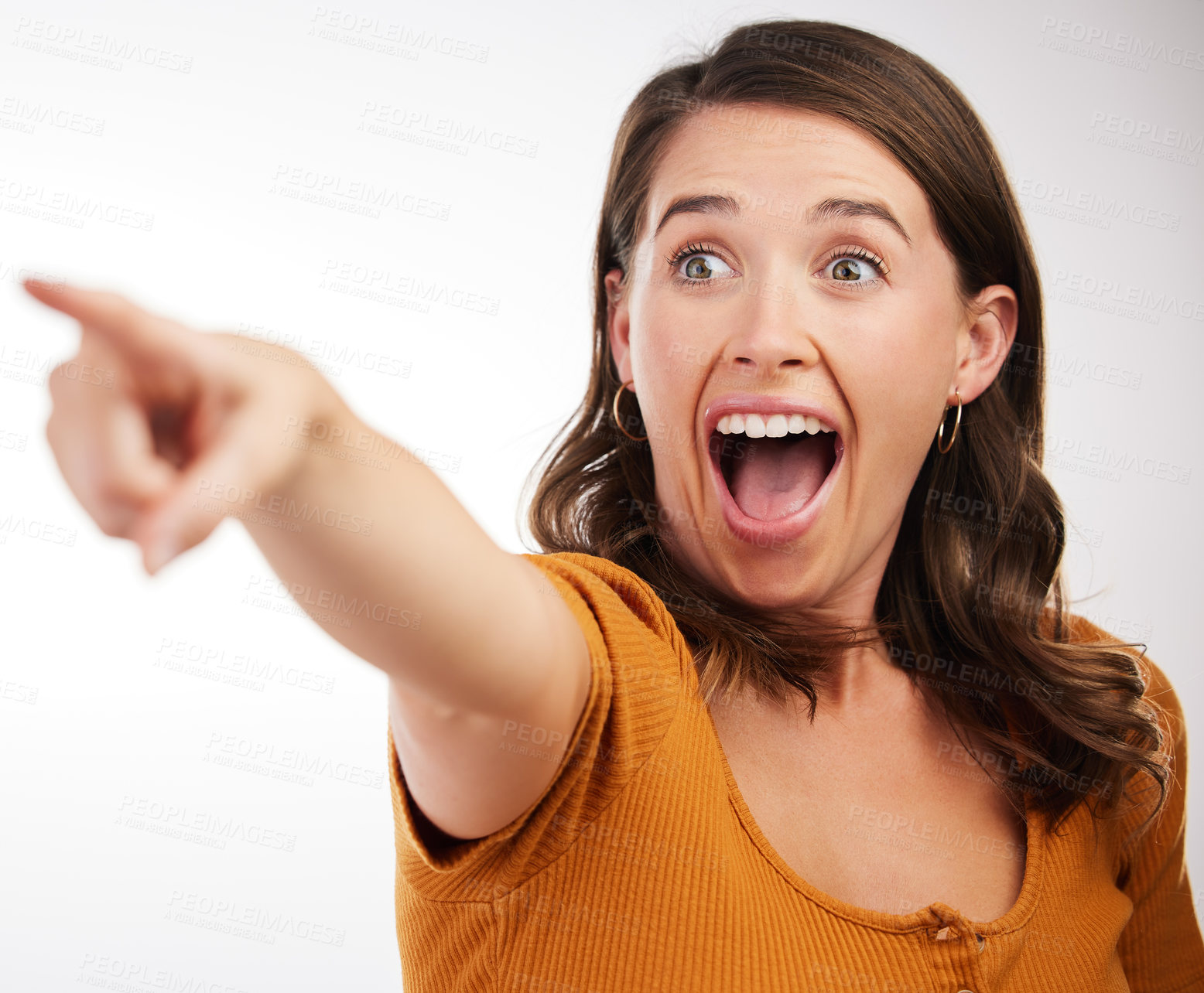 Buy stock photo Studio shot of a young woman pointing in a direction against a white background