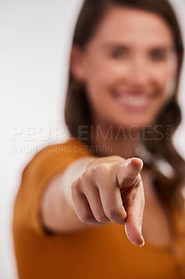 Buy stock photo Studio shot of a young woman pointing straight against a white background